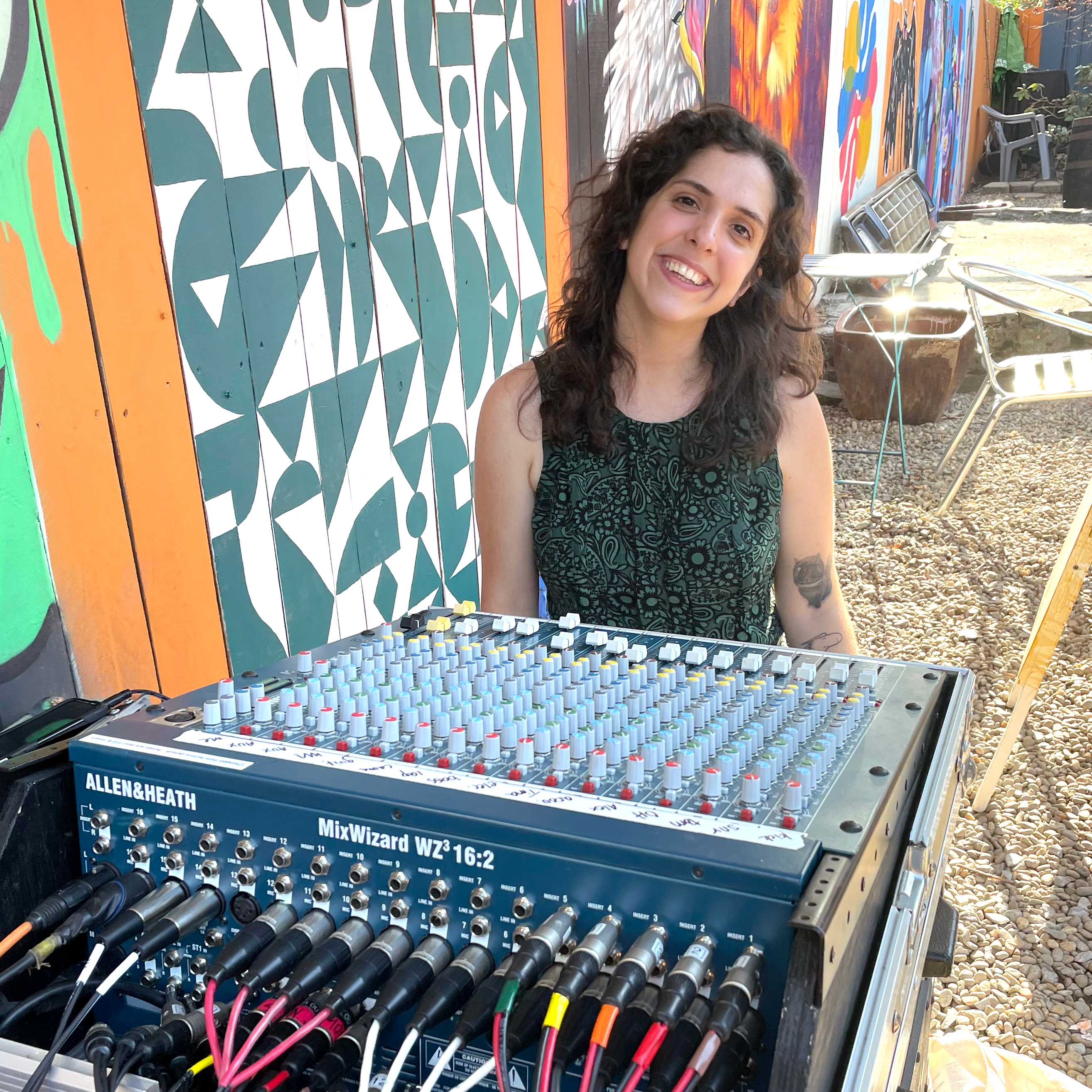 Jess Fox sitting at a large audio mixer.